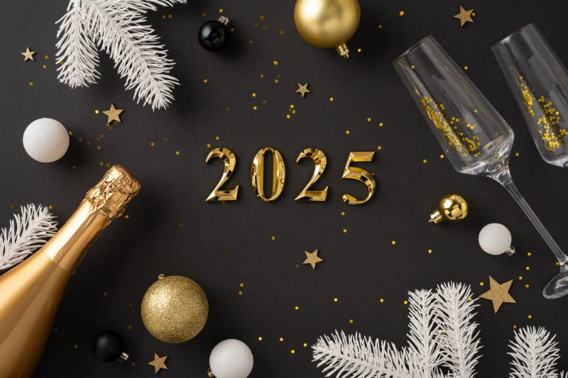 Home 50 Gold balloons forming 2025 surrounded by champagne bottle, glasses, white pine branches, gold and black ornaments, and confetti on a dark background, creating a festive New Year’s celebration scene.