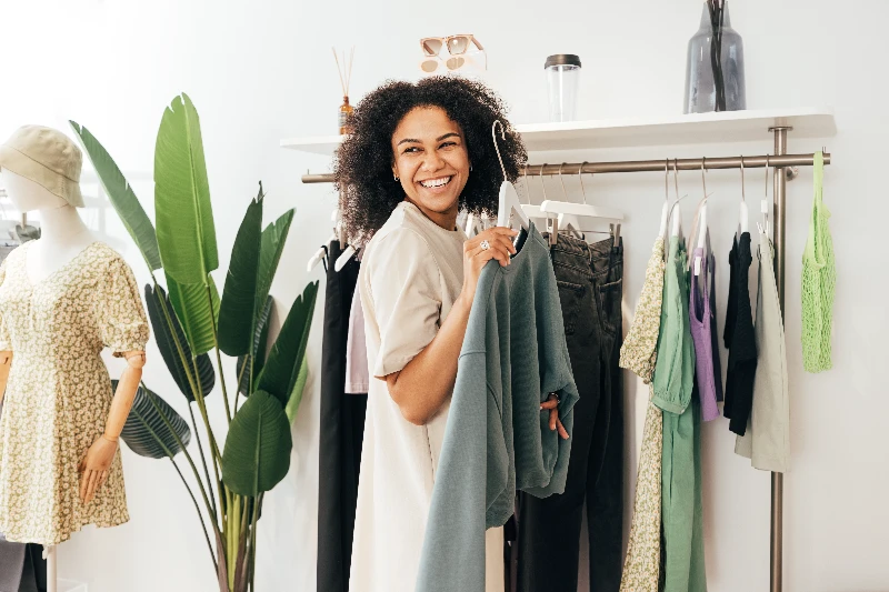 Home 20 Laughing woman customer choosing sweatshirt